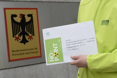 Eine Person hält einen Brief mit der Aufschrift "An den Bundesminister für Wirtschaft und Energie"" hoch. Im Hintergrund das Logo des Bundesministeriums für Wirtschaft und Energie.